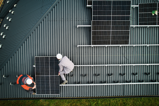 men-workers-installing-solar-panels-on-roof-of-hou-2023-11-27-05-30-51-utc